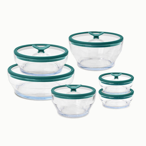 Six glass containers from the 12-Piece Glass Round Dish Set, each with a green lid, are arranged in two rows by size: three larger containers in the back and three smaller containers in the front.