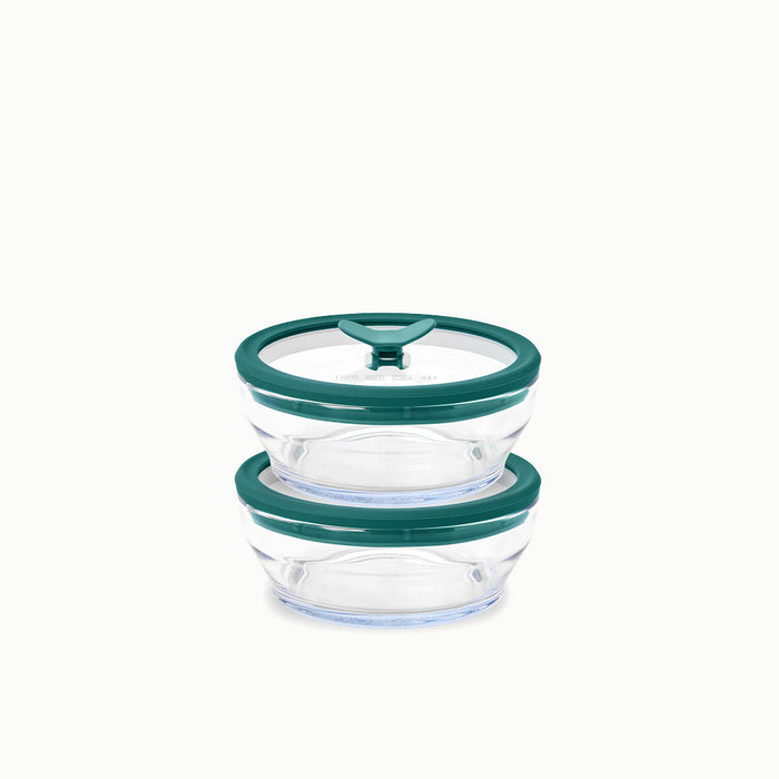 Two 2-Cup Glass Round Dishes with green lids are stacked on top of each other against a plain white background—ideal for storing leftovers or reheating food with ease.