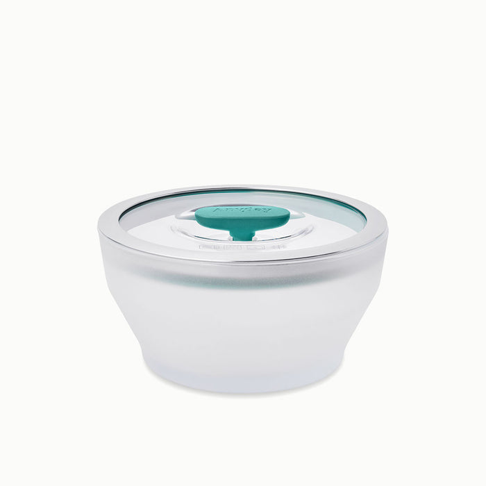The 4-Cup Glass Round Deep Dish features frosted glass construction with a clear lid and a teal circular vent in the center, making it ideal for steaming vegetables or reheating leftovers in the microwave; shown on a white background.