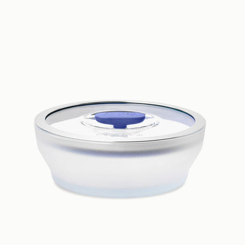 A 4-Cup Glass Round Shallow Dish with a transparent plastic lid featuring a blue slider in the center, designed for sealing and storing food—perfect for reheating leftovers or steaming green beans.