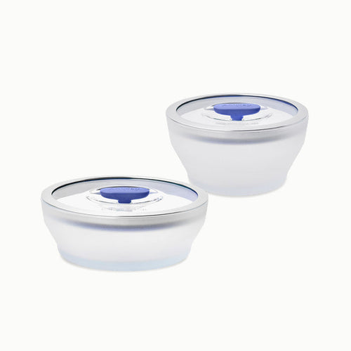 A set of two round, clear glass food storage containers with silver rims and transparent lids featuring blue silicone seals from the 4-Piece Glass Round Dish Set, displayed against a white background.