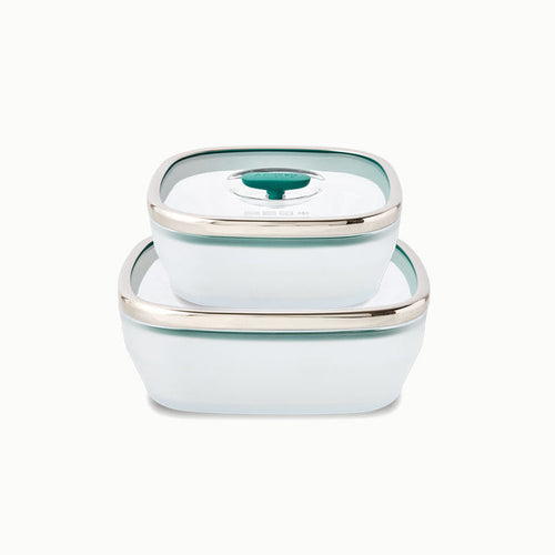 Two white, square glass dishes from the 4-Piece Glass Square Dish Set, each with a teal lid and silver rim, are stacked neatly—perfect for a plastic-free kitchen.