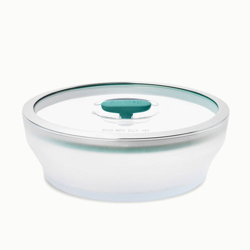 The 7-Cup Glass Round Shallow Dish features a frosted white base and a clear glass lid with a green silicone seal and center handle, making it perfect for steaming asparagus or reheating leftovers with ease.