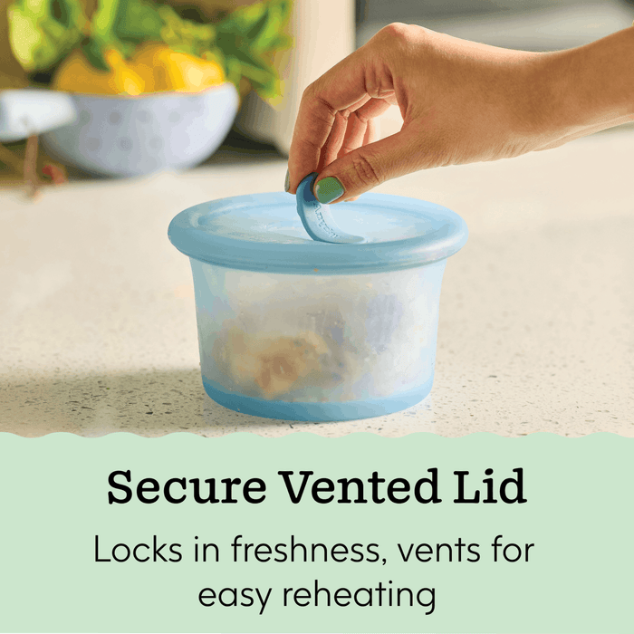 A hand lifts the tab on an Anydeli Mixed Set, 6-Pack blue-lidded food storage container made from platinum silicone on a kitchen counter. Text reads: Secure Vented Lid. Locks in freshness, vents for easy reheating.