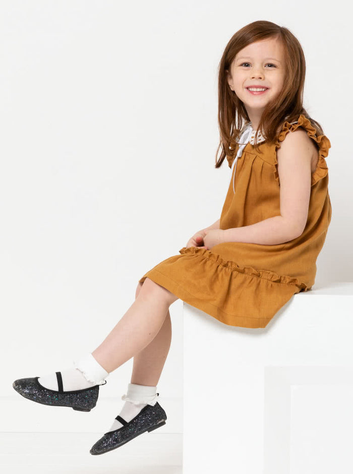 A child wearing dress made using Bonnie Kids Dress Sewing Pattern - A-line swing dress with frill hem and sleeves, Peter Pan collar, for kids ages 2-14, suitable for woven fabrics like linen, cotton, and rayon