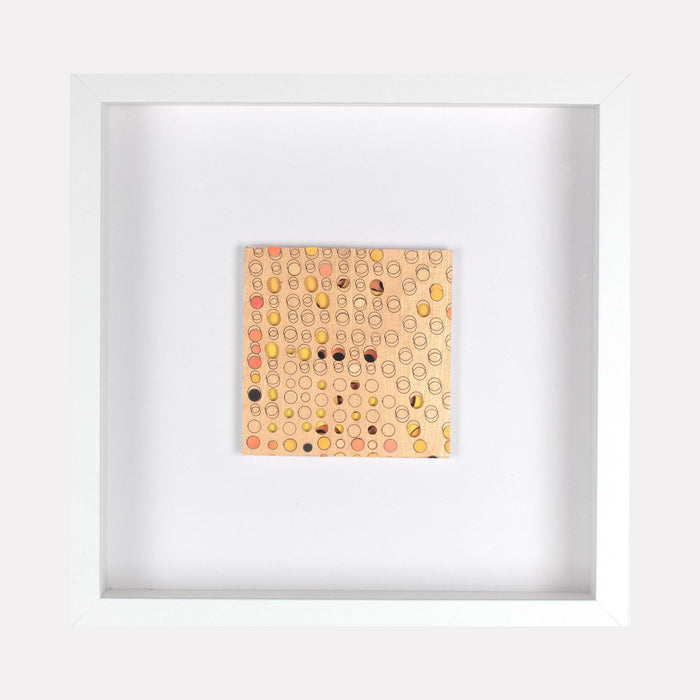 The artwork 'Ogilvy' by Margaret Griffith features a square composition of delicate circular patterns in soft peach and coral tones on cut paper. Small black dots are scattered throughout the geometric grid, creating a rhythmic abstract pattern. The piece is mounted in a clean white frame, measuring 9.75 x 9.75 inches, crafted with acrylic on cut paper.