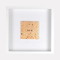 The artwork 'Ogilvy' by Margaret Griffith features a square composition of delicate circular patterns in soft peach and coral tones on cut paper. Small black dots are scattered throughout the geometric grid, creating a rhythmic abstract pattern. The piece is mounted in a clean white frame, measuring 9.75 x 9.75 inches, crafted with acrylic on cut paper.