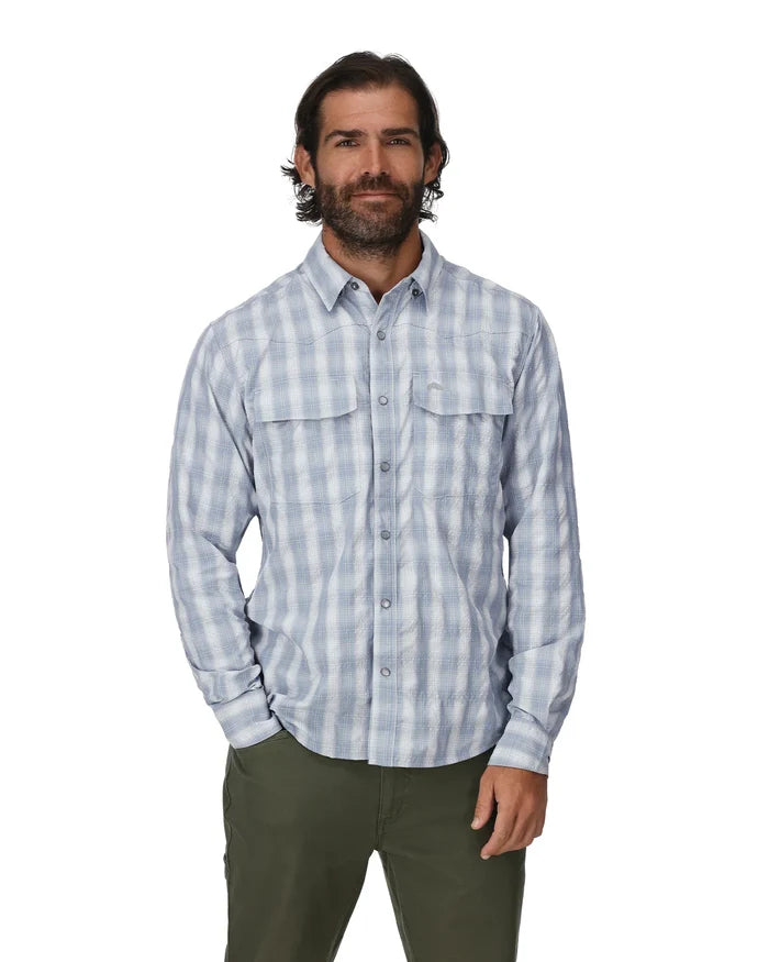 A man wearing Simms Big Sky long sleeve fishing shirt in bimini blue plaid.