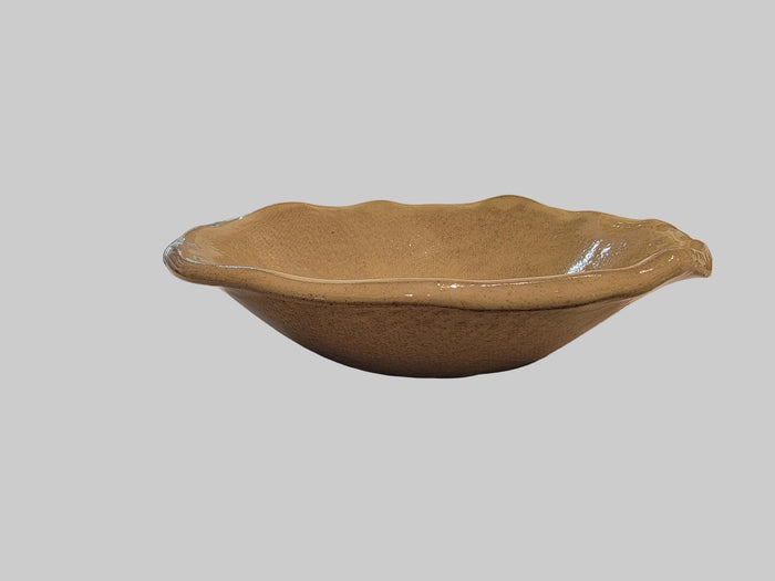 Small ceramic salad bowl with a blurred white background.