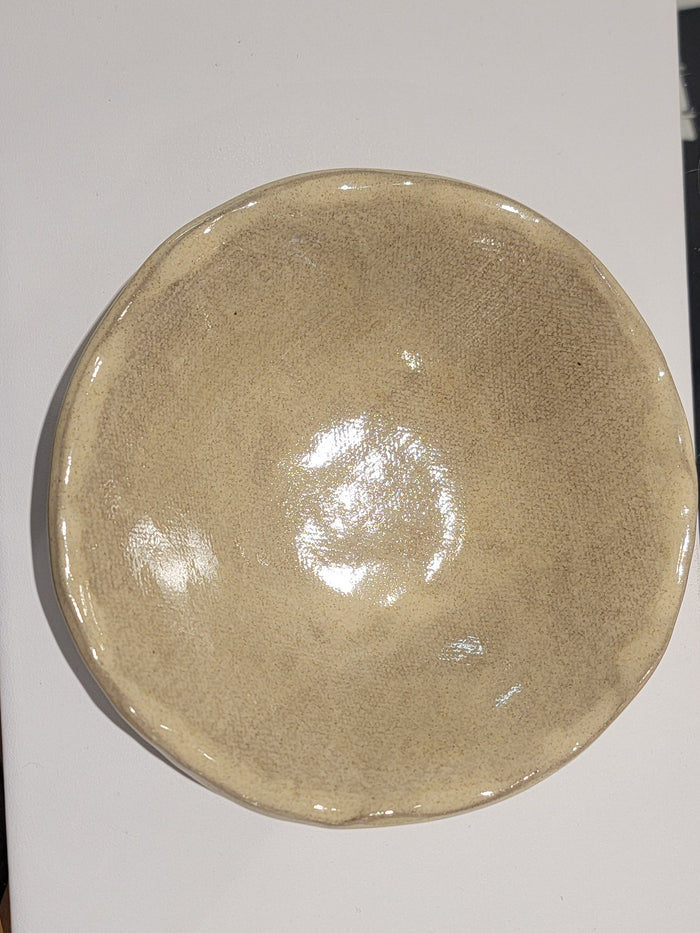 Ceramic bowl on a white sheet of paper with a blurred background