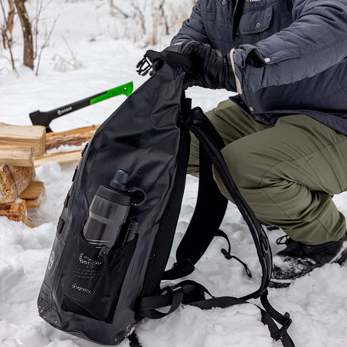 Person packing waterproof backpack in winter